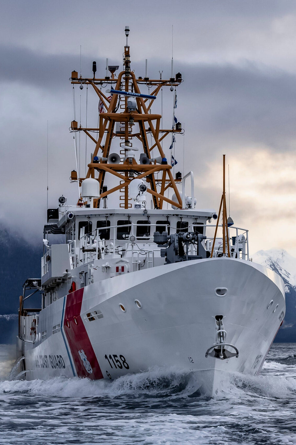 Coast guard ship navigating through water with mountains in the background